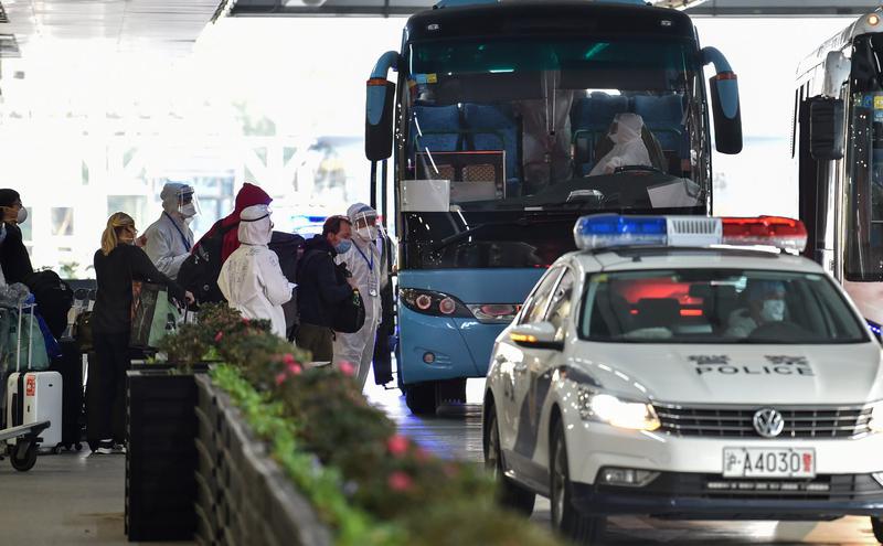 上海浦东国际机场的旅客接受安检后上车。