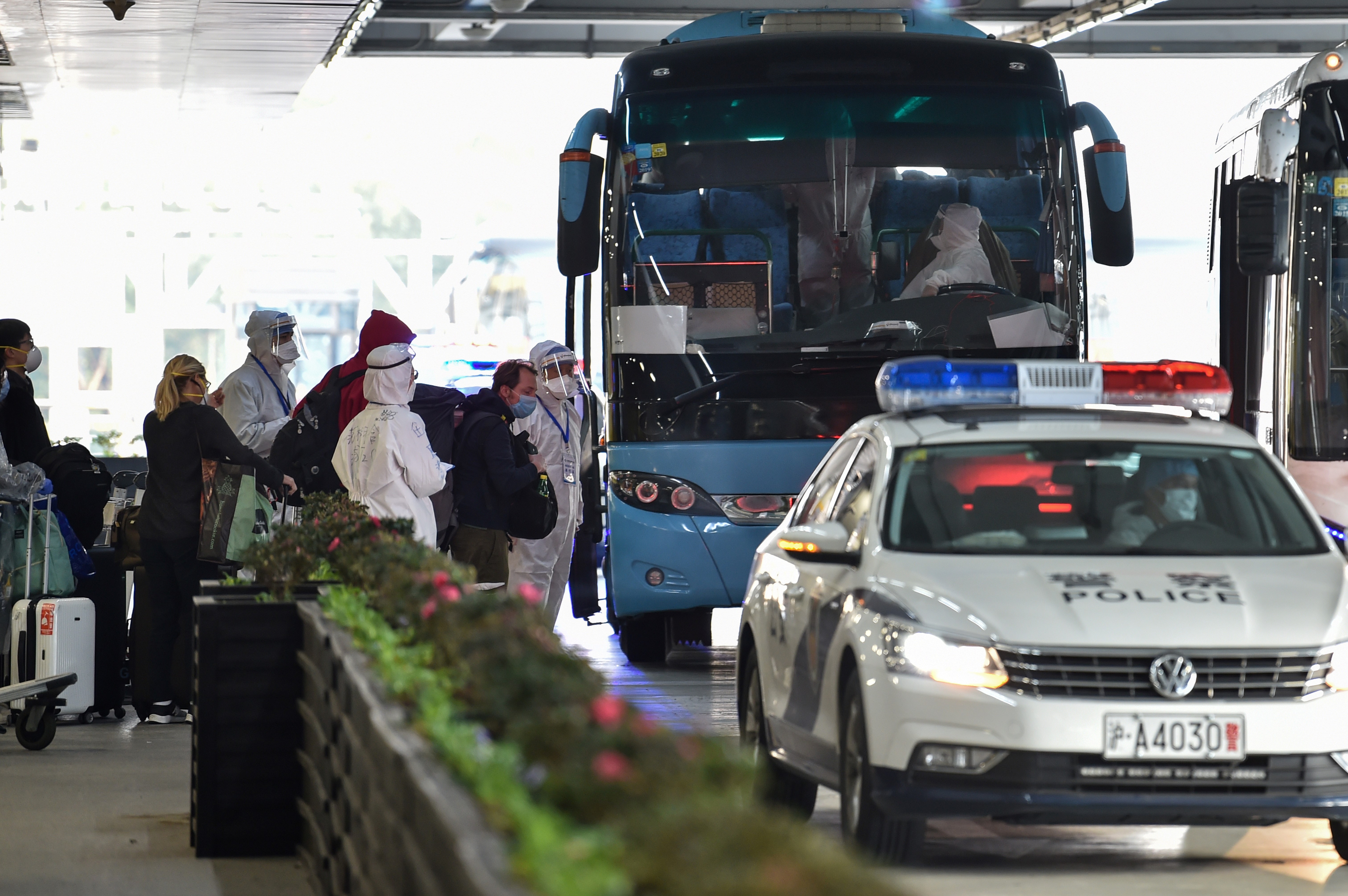 上海浦東國際機場的旅客接受安檢後上車。