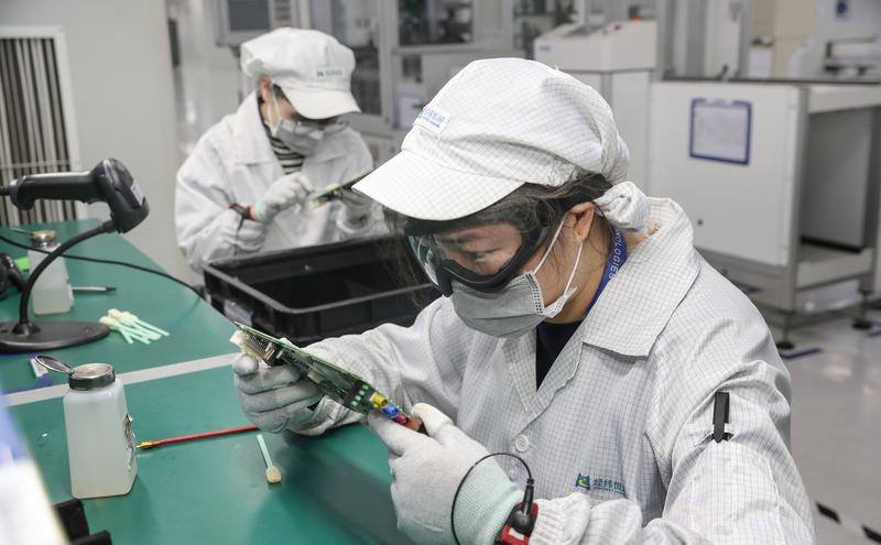 中國江蘇省南通市一家電子廠的工人戴着口罩復工。