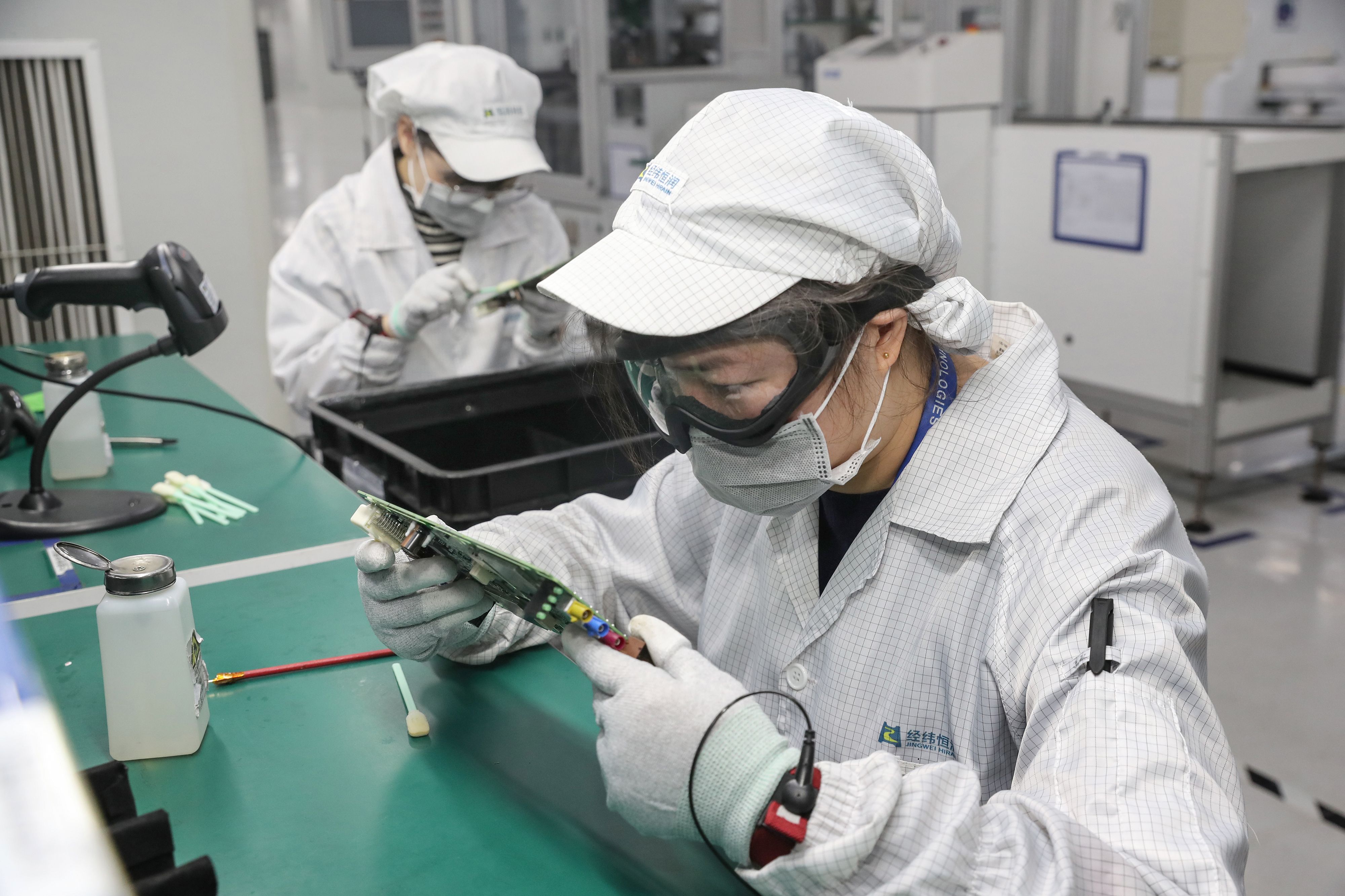 中国江苏省南通市一家电子厂的工人戴着口罩复工。