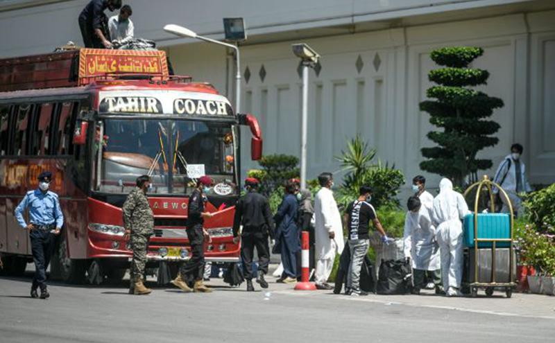 4月24日，巴基斯坦安全人员护送一辆载有国际旅行者的巴士抵达旅馆。