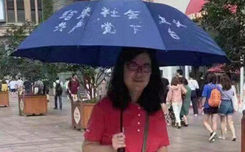 张展在上海南京东路步行街举伞。