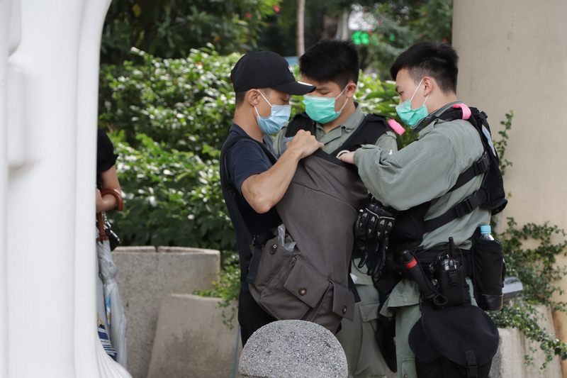 香港立法会二读国歌法，场外警员盘查可疑者（图片来源：中央社）