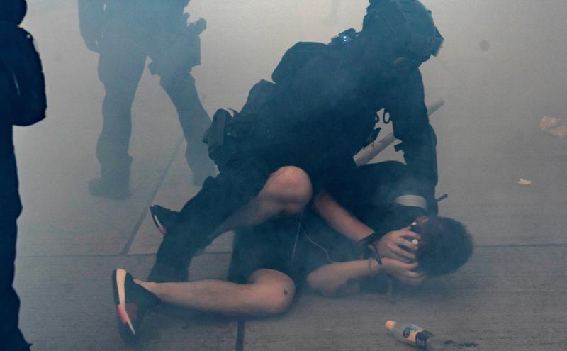 2019年10月香港示威者在催泪弹散发的烟雾中被港警逮捕。