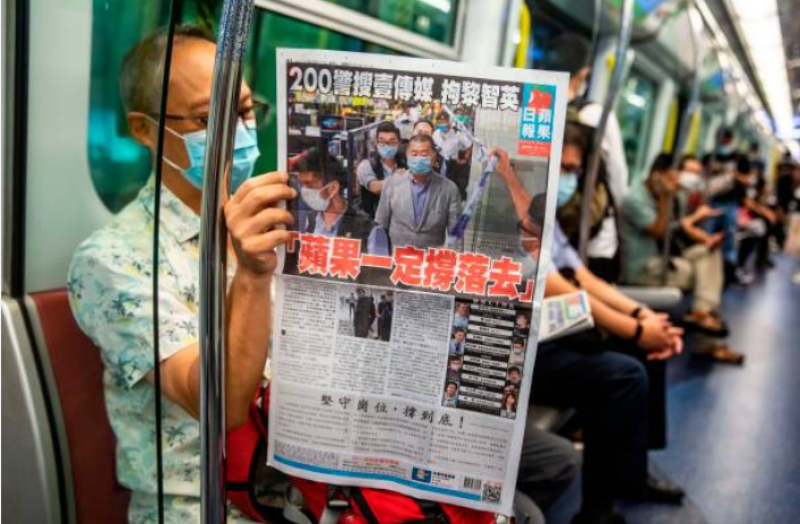 香港市民在地铁上阅览最新一期苹果日报