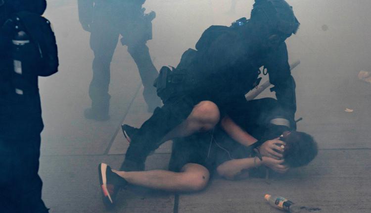 图为2019年10月香港示威者在催泪弹散发的烟雾中被港警逮捕