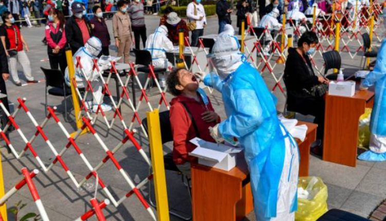 10月12日山东青岛一名工作人员正在为市民做核酸检测