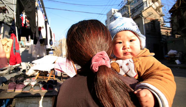 图为一位妈妈带着孩子走在上海街头