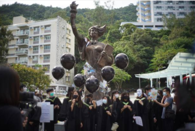 香港中文大学毕业生手持黑色气球在民主女神像前合影