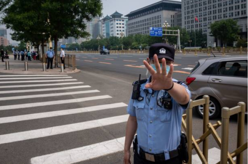 图为北京警察阻止记者拍照