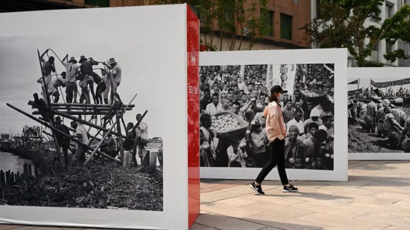 6月12日，北京一名女子走到中共百年图片展。
