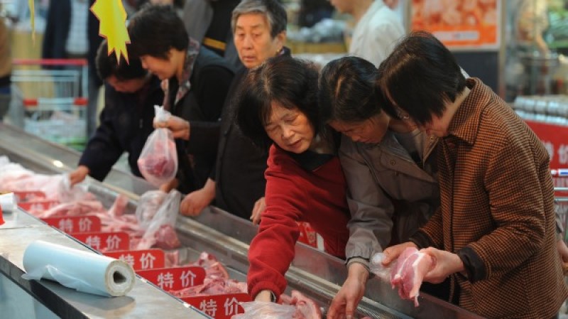图为中国民众在挑选猪肉
