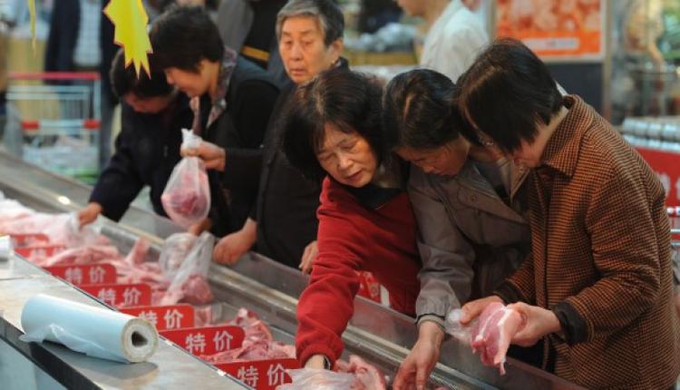 图为中国民众在挑选猪肉