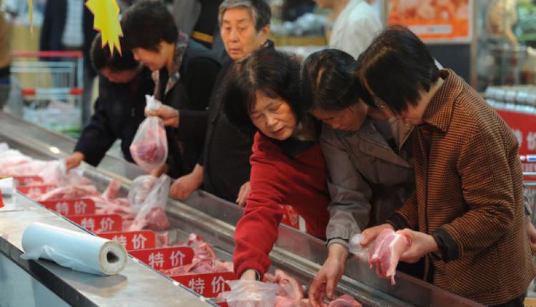 图为中国市民在市场挑选猪肉