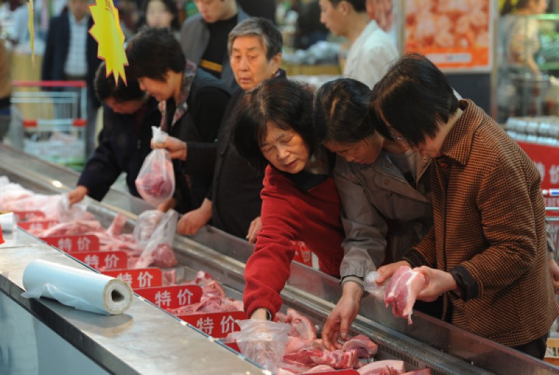 图为中国市民在市场挑选猪肉
