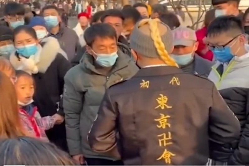 1月3日，在江苏南京，一名年轻男子身穿日本服饰，在玄武湖公园内被游客围堵