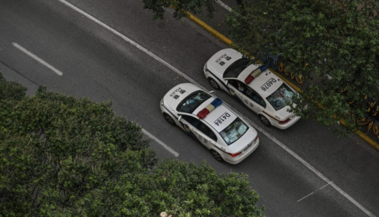 在上海静安区进行 COVID-19 封锁期间，警车在街道上行驶。