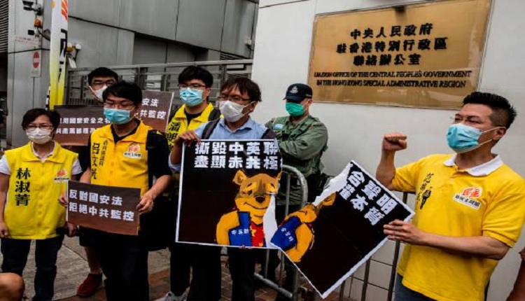 港人2020年5月24日在香港中联办外抗议拟议的港区国安法时，亲民主活动人士撕毁了代表习近平的小熊维尼标语牌。