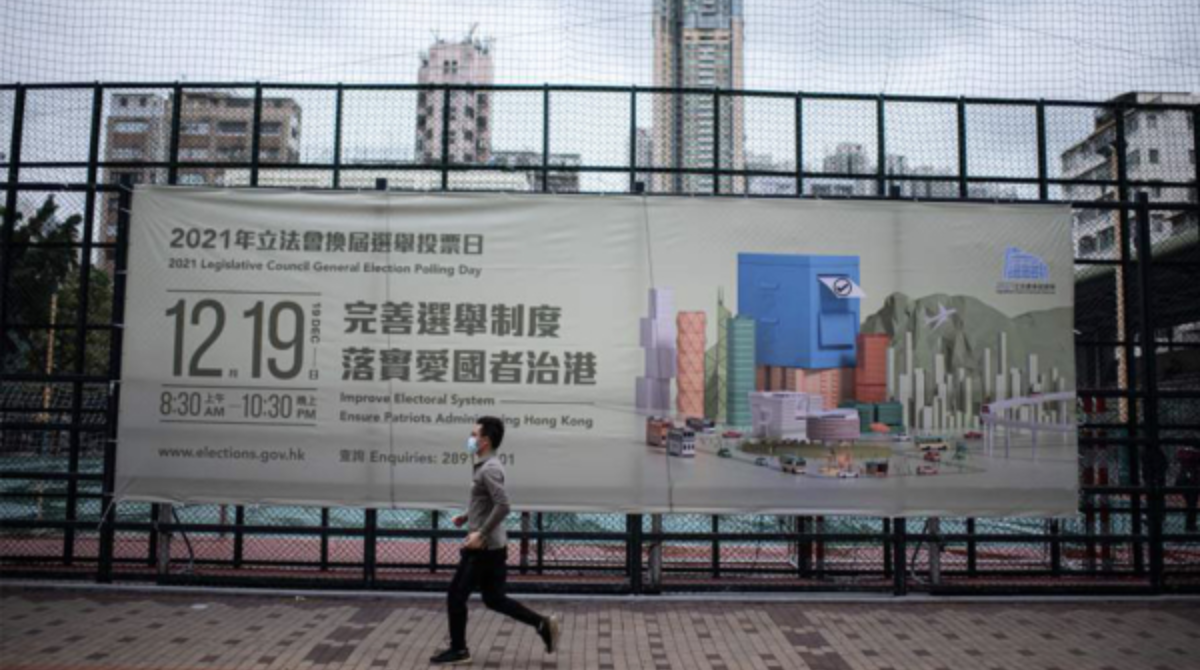 图为一位市民经过巨型选举广告