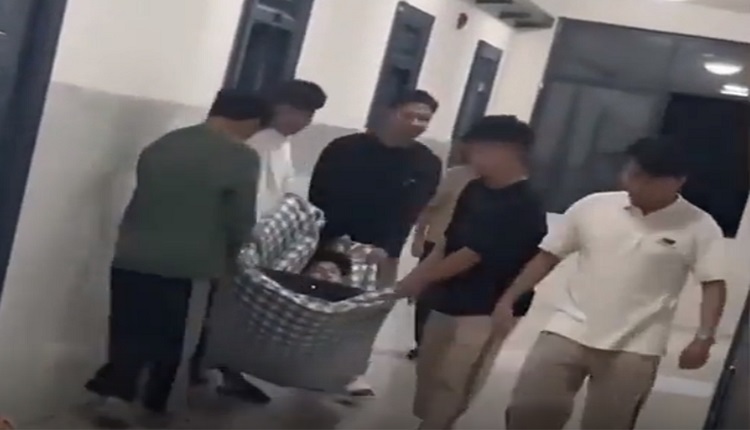 打呼噜太吵被“丢包”房外 男同学继续睡 被人拍醒后一脸茫然