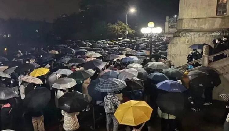 武汉大学学生冒雨抗议。