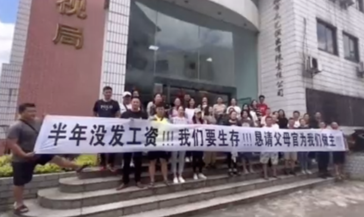 桂林市广播电视局门口有人拉横幅，声称八个月未发工资