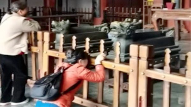 一名女子在中国河南省开封包公祠跪地痛哭