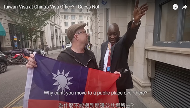 英国网红路易斯在中国签证申请服务中心外手持青天白日满地红旗拍摄，被保安阻挠。
